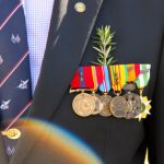 Image of ANZAC returned serviceman wearing rosemary with his medals.